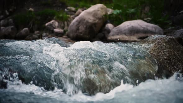Close up of river stones with flowing water, clean water flowing in a mountain river