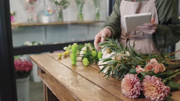 Unrecognizable Florist With Digital Tablet alt
