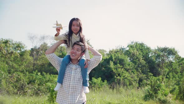 Happy family picnic. Asian father and daughter playing toy airplane and have enjoyed together