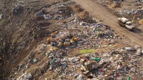 Flight Over Trucks Bringing Waste To a Garbage Pile in Trash Dump. Aerial View of Large Garbage Pile alt