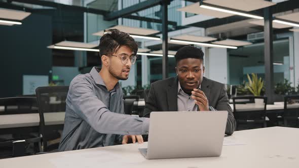 Two Multicultural Professional Male Coworkers Men Colleagues Sit at Office Use Laptop Discuss alt