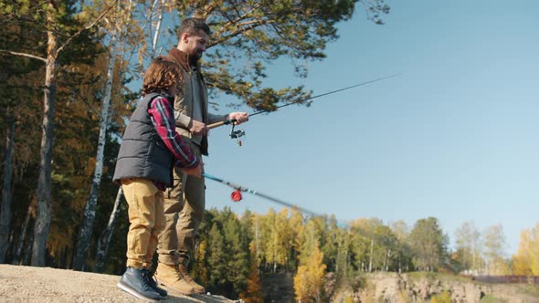 Dad and Child Catching Fish Enjoying Sunny Day Outdoors in Leisure Time alt
