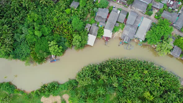 An aerial view over a fishing village by a canal in the countryside alt