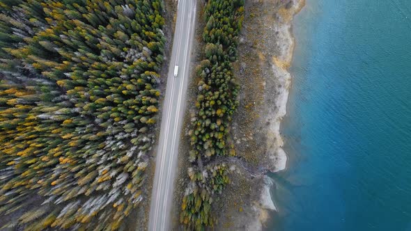 Bird's eye video showing shores of Spray Lakes Reservoir and a forest road nearby in Alberta, Canada alt