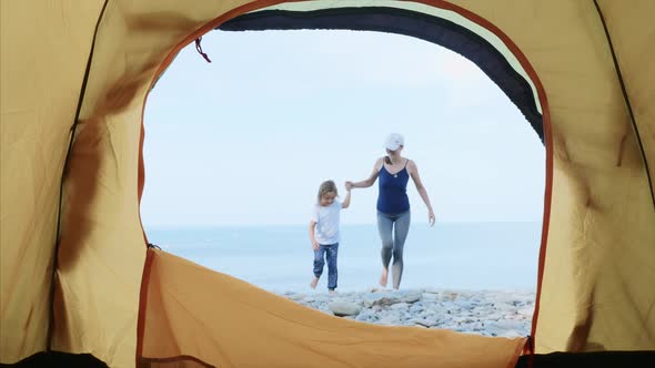Young Woman with Her Little Daughter Enter the Camping Tent Resting By Sea