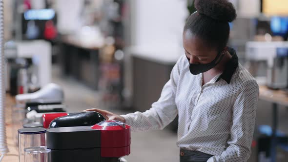 Young Afroamerican Woman in Kitchen Appliances Store Young Female Shopper is Choosing Automatic alt