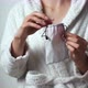 Woman In White Coat Hides Menstrual Cup In Pouch. Closeup Of Young Women Hands Holding Menstrual Cup