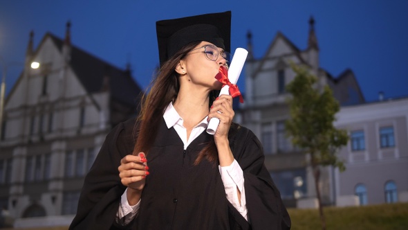 Excited female graduate dancing in academic . alt