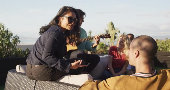 Group of friends drinking beers and discussing on a rooftop alt