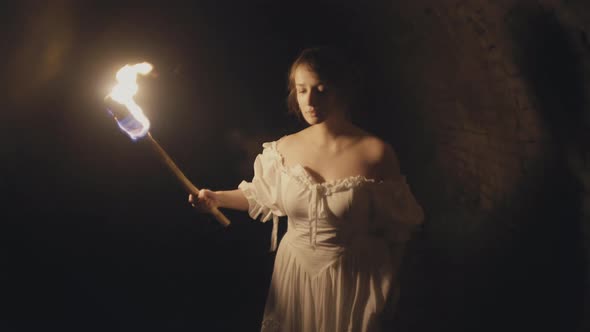 Girl Holding Fire Torch in Medieval Dungeon