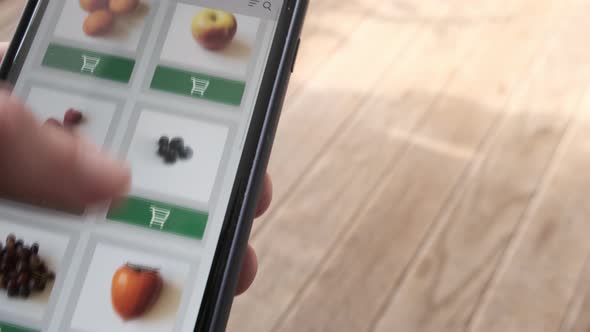 Concept of Ordering Food Vegetables and Fruits Online Using Smartphone App Close Up alt