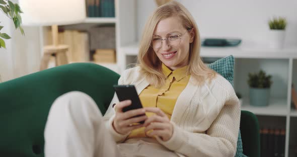 Woman on Sofa with Smartphone