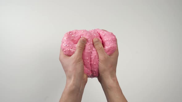 Top View: Hands Massaging Pink Slime Then Stretch It, White Background alt
