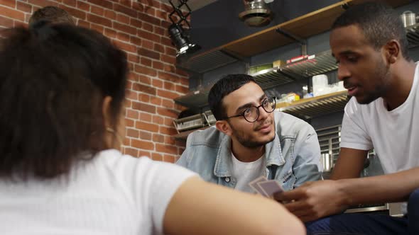 Multiracial friends playing card game