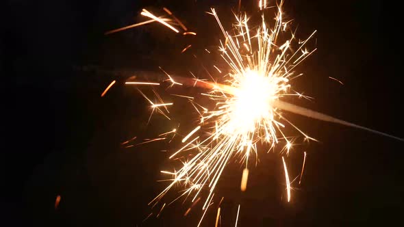 Handheld firework sparkle isolated on black. New year concept