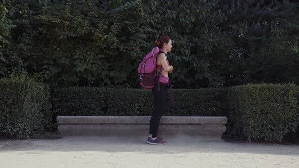 Sportswoman lying on stone bench in park alt