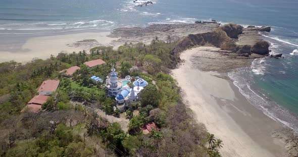 Aerial drone view of the beach, rocks and tide pools in Guiones, Nosara, Costa Rica alt