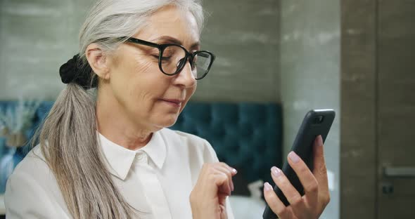 Aged Woman Texting on Smartphone