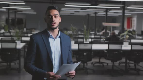 Young Arab Businessman in Formal Suit Smiling to Camera Posing at Modern Office Interior Tracking alt