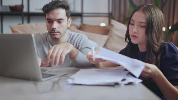 home finance,husband and wife discussing paper bill receipt together