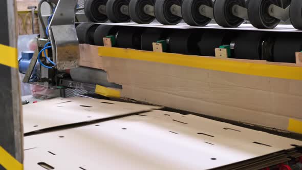 Conveyor line for the production of  boxes. Machine carves cardboard boxes from sheets of cardboard