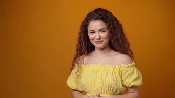 Positive Young Woman Laughing Against Yellow Background
