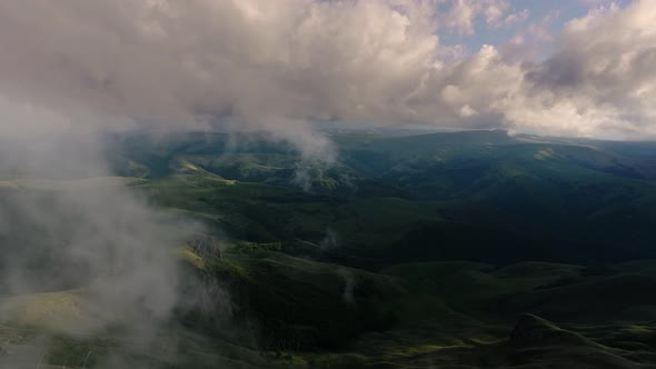 Low Clouds Over a Highland Plateau in the Rays of Sunset alt