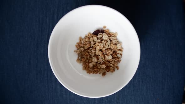 Healthy Breakfast of Cereal is Being Put in White Plate Placed on Blue Table