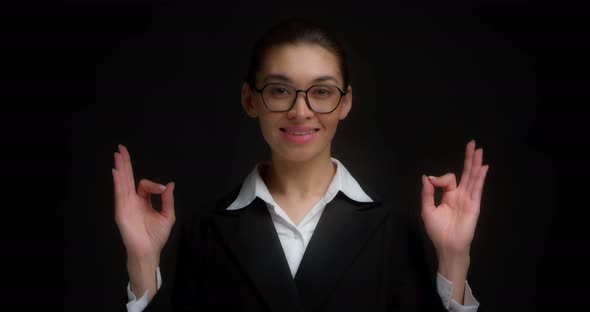 Business Woman with a Smile on Her Face Shows the Ok Sign with Both Hands
