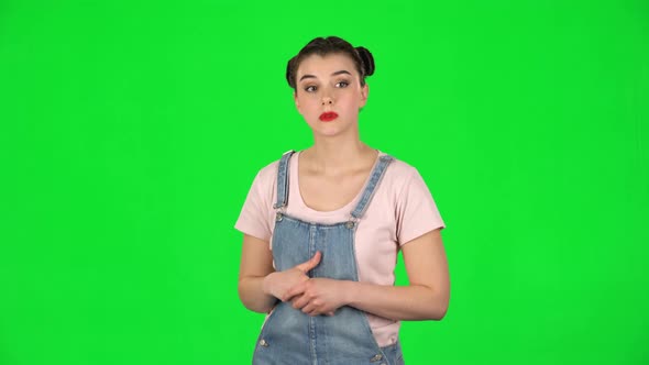Young Woman Stands Waiting with Boredom on Green Screen alt