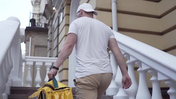 Delivery Man Arrives at Residential Address To Deliver Food Order To Customers