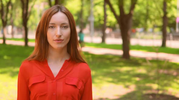 Pretty Lady in Orange Blouse Posing in Park