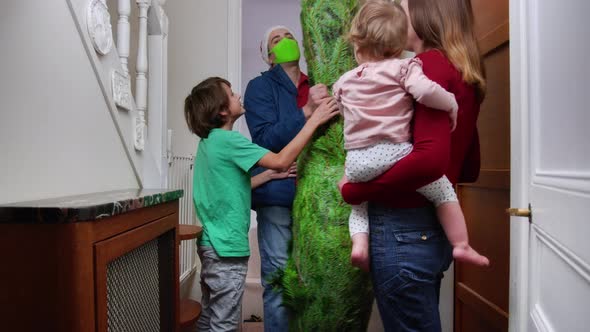 Delivery Man in Mask Bring Christmas Tree to Home alt