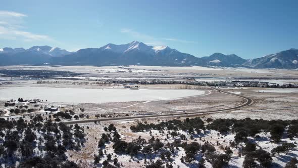 Colorado's highway 285 with the snowy Collegiate Peaks in the background, aerial alt
