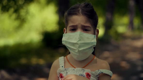 Children In Face Mask.Epidemic Coronavirus On Nature Outdoors. Kid Girl Walking In Protective Mask. alt