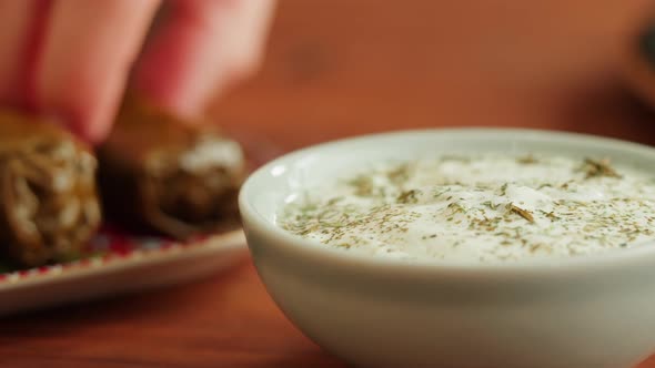 Eating Dolma with Sour Cream Closeup Meat in Grapes Leaves Middle Eastern National Traditional Food alt