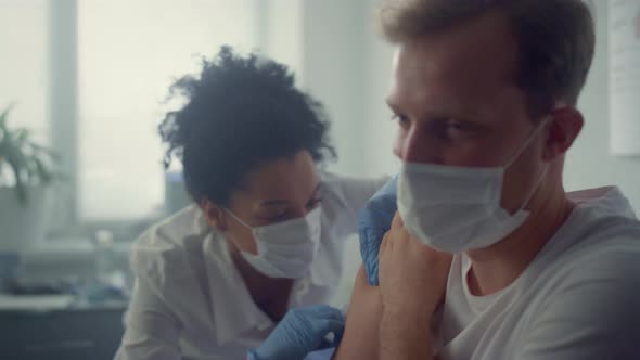 Doctor Injecting Vaccine Patient Shoulder in Health Clinic alt