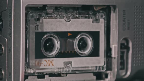 Audio Cassette in the Tape Recorder Playing and Rotates alt