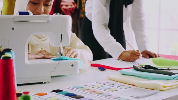 Muslim women fashion designers are in process of creating new clothes collection. alt