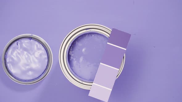 Close up of metal paint can with purple paint and paint swatch. alt