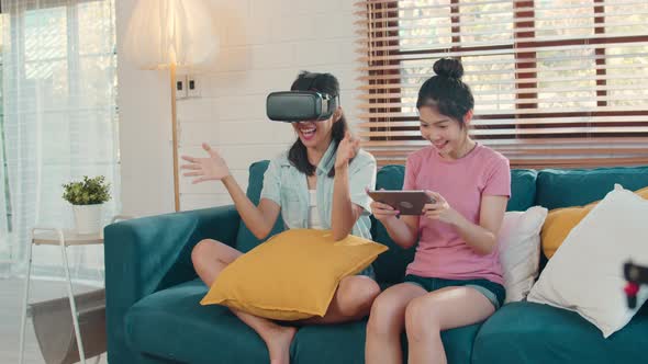 Female feeling happy fun and virtual reality, VR playing games together while lying sofa. alt