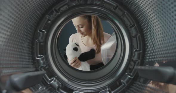 Woman washing a cute plush in the washing machine