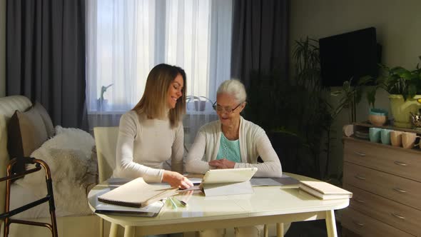 Beautiful Woman Reading Letter and Watching Pictures with Grandma