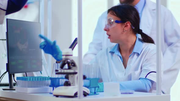 Biochemist Writing on Computer the Changes in Vaccine Composition alt