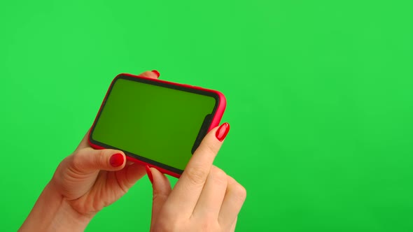 Female Hand Holds Mobile Phone with Workspace Mock Up Screen on Green Background in Horizontal alt