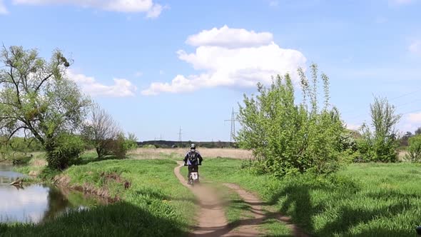 Male motocross driver riding his FMX motorcycle on the extreme off-road track alt