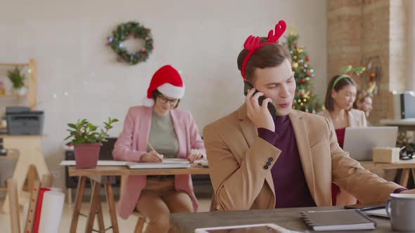 Businessman in Festive Headband Posing in Office on Christmas alt