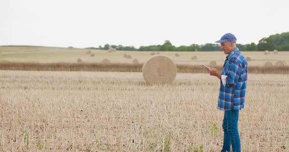 Farmer Using Digital Tablet on Field Agriculture alt