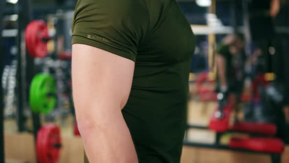 Closeup View of a Sporty Man's Strong Hand Doing Dumbell Curl Exercises in Gym alt