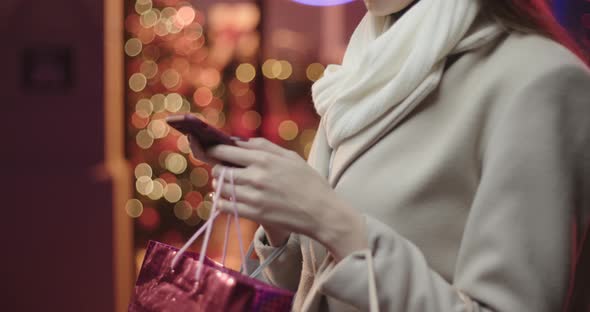 Side view of a young woman typing a message on her smatphone